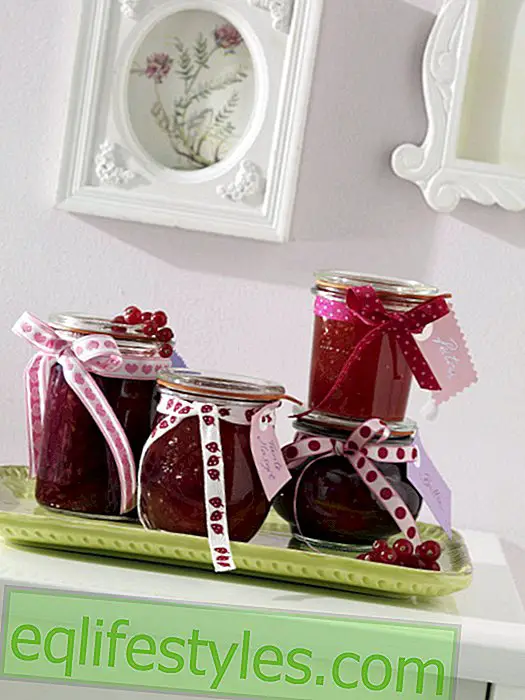 Decoration with berries: red fruit jelly in mason jars as a give-away